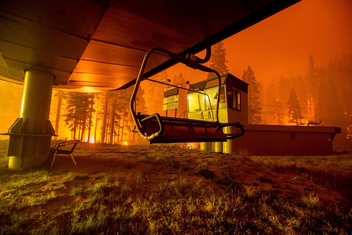 Seen in a long camera exposure, the Caldor Fire burns at Sierra-at-Tahoe ski resort on Monday, Aug. 30, 2021, in Eldorado National Forest, Calif. A father and son have been arrested on suspicion of starting a massive California wildfire that forced tens of thousands to flee the Lake Tahoe area earlier this year, officials said Wednesday, Dec. 8, 2021. The El Dorado County District Attorney’s office said in a statement that David Scott Smith and his son, Travis Shane Smith, are accused of reckless arson in a warrant issued before formal charges are filed.   (Noah Berger)
