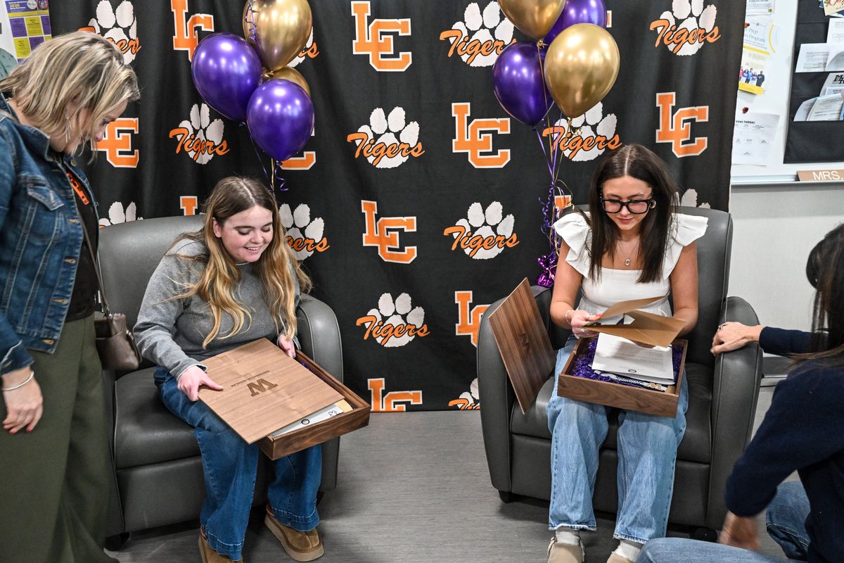 With their moms looking on, Lewis and Clark High School seniors Josephine Corbin, left, and Claire Poulsen explore the gift boxes containing their UW Presidential Scholarship awards on Friday at a surprise announcement at the school. Each student receives a $10,000 annual scholarship, renewable for four years. Only about a dozen of the awards are given out each year. (Jesse Tinsley/THE SPOKESMAN-REVIEW)