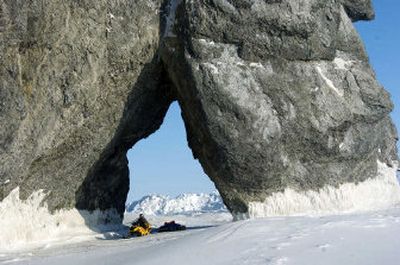 
Jim Knight of Deer Park rides through a giant arch jutting into the ocean near Chariot during a 2,000-mile snowmobile trek on the Iditarod Trail and continuing from Nome to Barrow. He traveled with Bob Jones of Kettle Falls. 
 (Photo by Bob Jones / The Spokesman-Review)