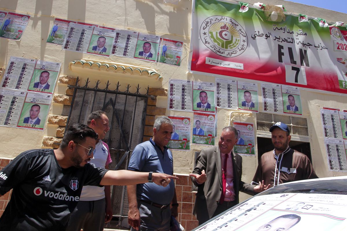 Men argue by electoral posters in Ain Ouessara, 190 kilometers (118 miles) from Algiers, Thursday, June 10, 2021. In addition to the traditional parties, dozens of independent candidates have decided to take part in the legislative elections on June 12, that the government organized earlier than expected under a new system meant to weed out corruption and open voter rolls — a major step in President Abdelmadjid Tebboune