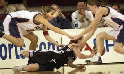 
Gonzaga players Delphine Lecoultre, left, and Ashley Burke, right, pressure Portland's Whitney Grant after she fell to the floor in the first half of the West Coast Conference Tournament opener. 
 (Brian Plonka / The Spokesman-Review)