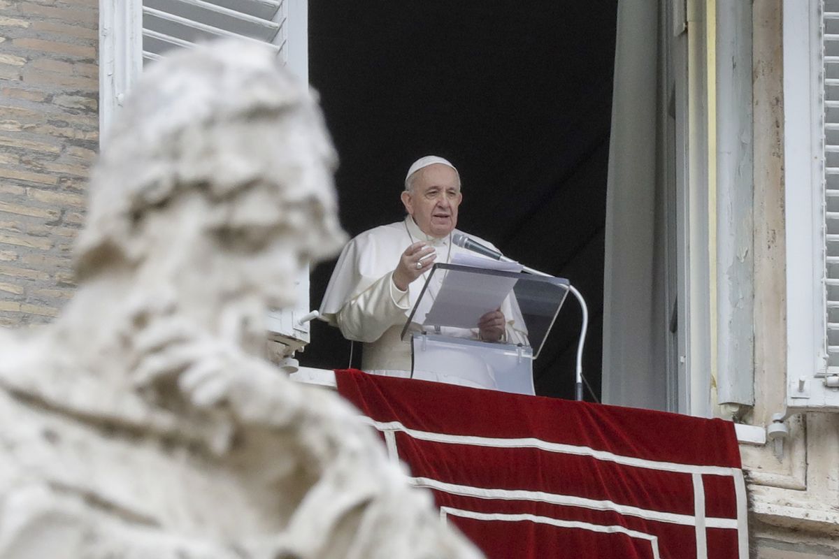 In this Dec. 8, 2020 photo, Pope Francis delivers his message during the Angelus noon prayer from the window of his studio overlooking St.Peter