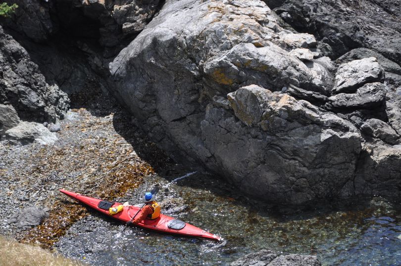 A sea kayaker pulls in for a break near Lime Kiln Point, a 36-acre Washington State Park on the west side of San Juan Island. The day-use park is a popular destination for island visitors and bicyclists. It's known as a standout land-based facility for viewing whales.  (Rich Landers)