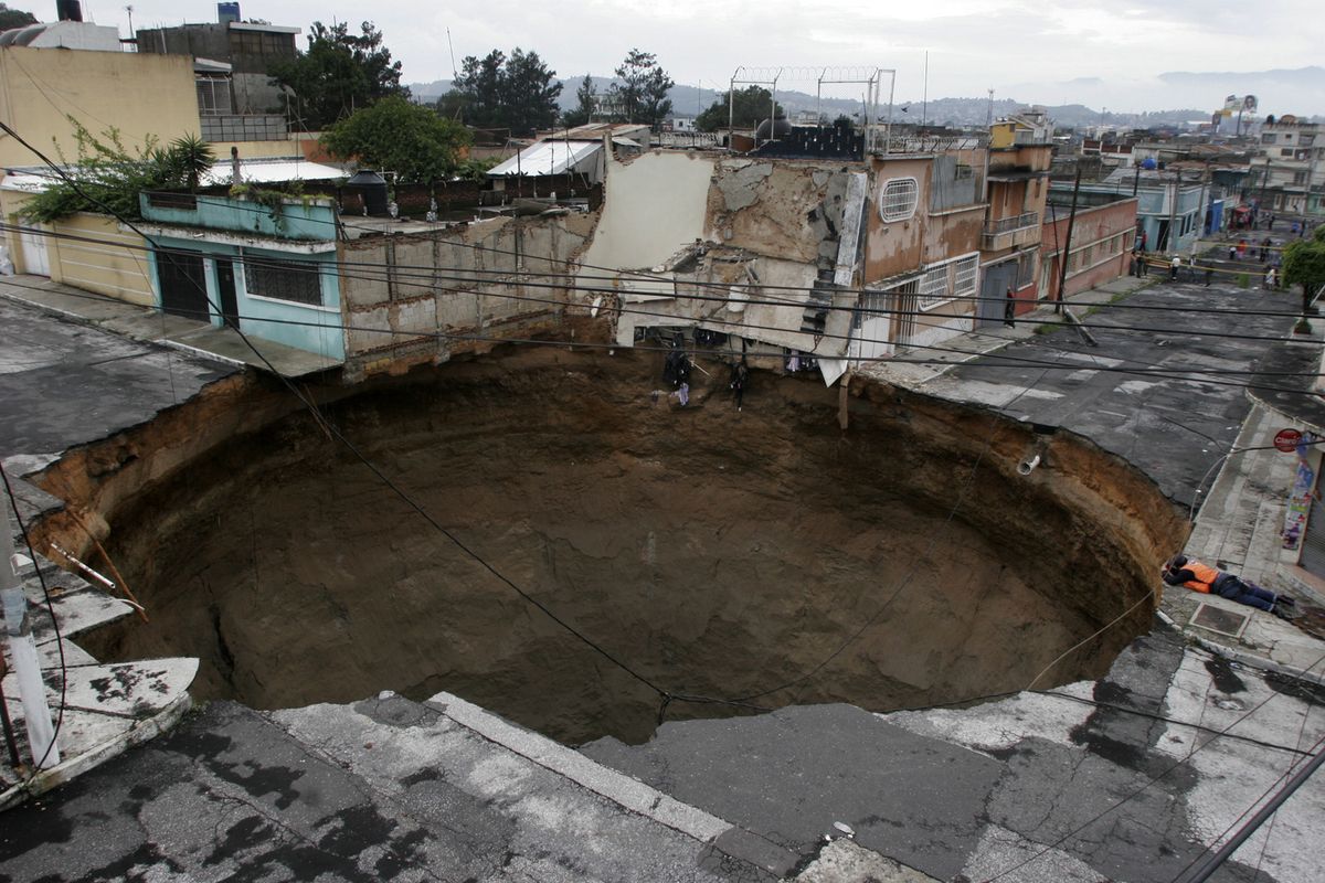 A sinkhole created by Tropical Storm Agatha covers a street intersection in downtown  Guatemala City on Sunday.