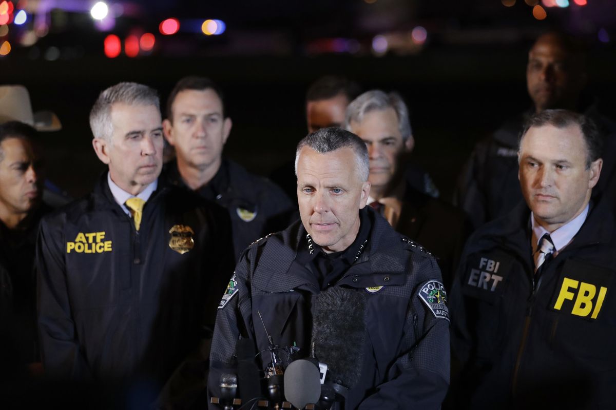 Austin Police Chief Brian Manley, center, stands with other members of law enforcement as he briefs the media, Wednesday, March 21, 2018, in the Austin suburb of Round Rock, Texas. The suspect in a spate of bombing attacks that have terrorized Austin over the past month blew himself up with an explosive device as authorities closed in, the police said early Wednesday. (Eric Gay / AP)