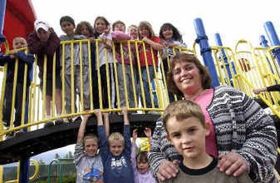 
Dagon Hall, 7, front, spends afternoons with a handful of other children and Skyway Elementary's School Plus site coordinator Annette Folk, right, at the school. 
 (Jesse Tinsley / The Spokesman-Review)
