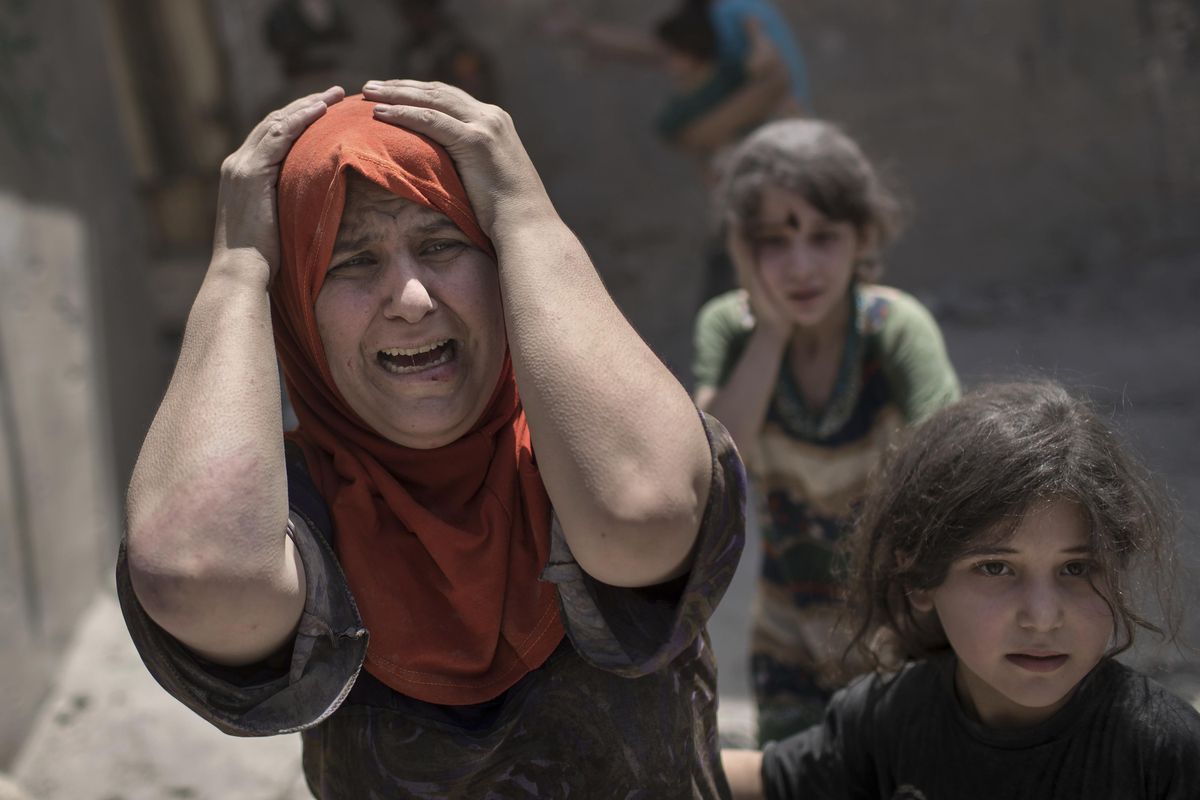 A woman screams while fleeing with her family through a destroyed alley, as Iraqi special forces continue their advance against Islamic State militants, in the Old City of Mosul, Iraq, Sunday, July 2, 2017. (Felipe Dana / Associated Press)
