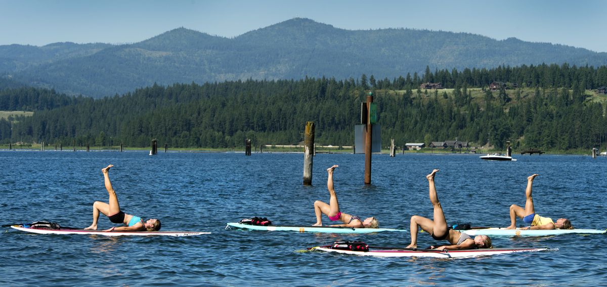 Rachel Rowley, Amy Gates, Jenni Niemann and instructor Katie Fitzgerald participate in paddleboard yoga recently on Lake Coeur d’Alene. (Dan Pelle)