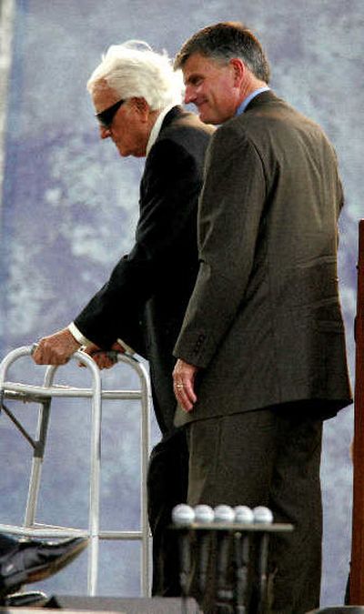 The Rev. Billy Graham is helped off stage by son Franklin after speaking in New York on Sunday. 
 (Associated Press / The Spokesman-Review)