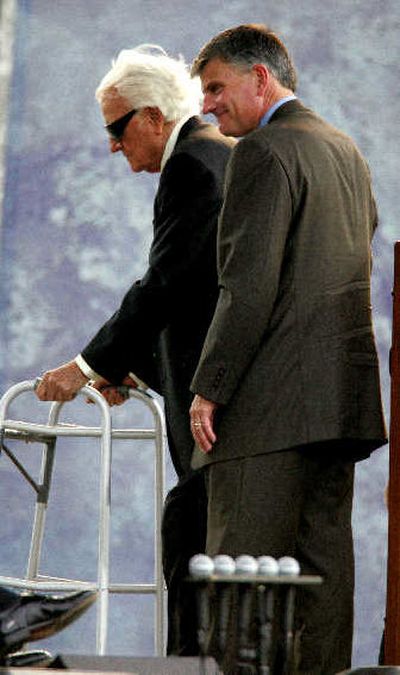 The Rev. Billy Graham is helped off stage by son Franklin after speaking in New York on Sunday. 
 (Associated Press / The Spokesman-Review)