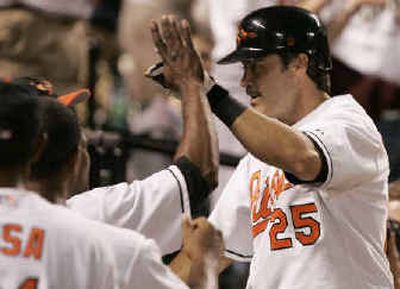 
Baltimore's Rafael Palmeiro is congratulated after hitting a home run off hard-luck loser Ryan Franklin. 
 (Associated Press / The Spokesman-Review)