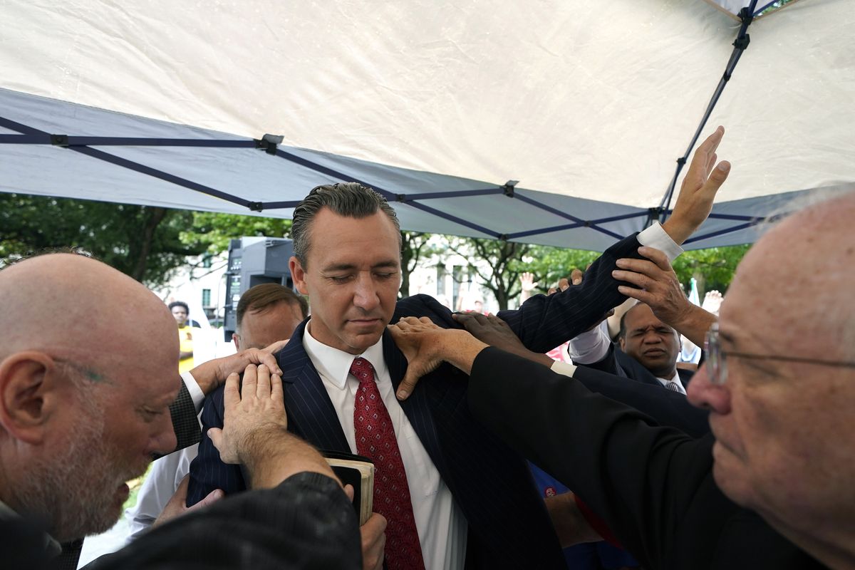 FILE - In this June 7, 2021 file photo, Tony Spell, pastor of the Life Tabernacle Church of Central City, La., prays with supporters outside the Fifth Circuit Court of Appeals in New Orleans. Health officials have an unsteady partner as they try to get more people vaccinated against COVID-19 in the Bible Belt: churches and pastors. Some preachers are praying for more inoculations and hosting vaccination clinics. Others are skirting the topic of vaccines or openly preaching against them in a region that