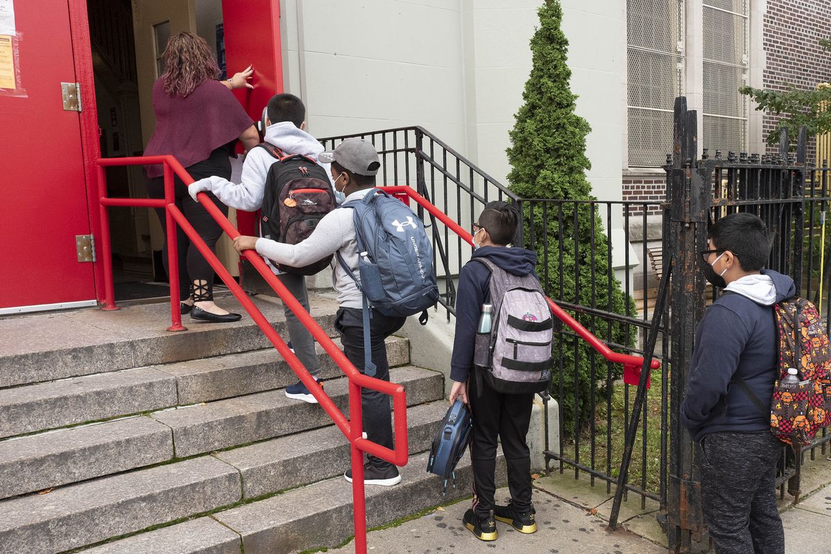A teacher leads her students into an elementary school in the Brooklyn borough of New York on Tuesday, Sept. 29, 2020, as hundreds of thousands of elementary school students are heading back to classrooms in the city, resuming in-person learning during the coronavirus pandemic. The coronavirus is infecting a rising number of American children and teens in a trend authorities say appears driven by school reopenings and the resumption of sports, playdates and other activities. (Mark Lennihan)