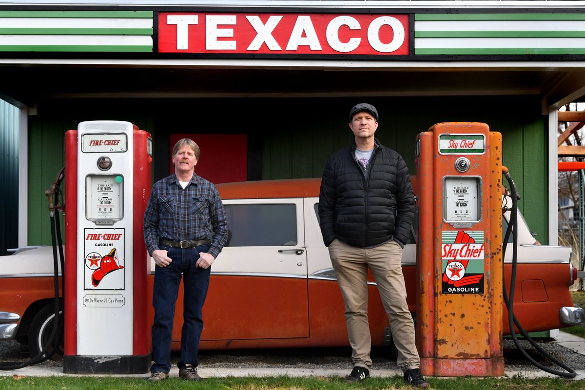 Chuck King, host of “Chuck King’s Guide to Spokane History,” and Garrin Hertel, the new show’s producer, director and editor, stand for a photograph in King’s backyard with some of King’s automotive memorabilia on Wednesday in Spokane Valley.  (Tyler Tjomsland/The Spokesman-Review)