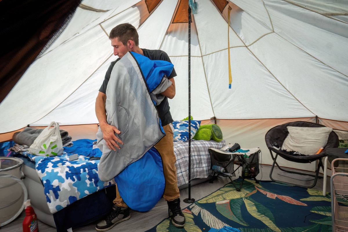 Kyle Roberson straightens up his tent in the heart of Camp Hope, a homeless encampment of over 600 people living along Second Avenue at Ralph Street.  (COLIN MULVANY/THE SPOKESMAN-REVIEW)