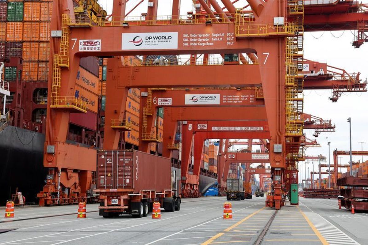 A truck carries a container near a cargo ship bound for Japan at the Center container ship terminal at the Port of Vancouver on Aug. 3, in Vancouver, British Columbia.  (Chris Helgren)
