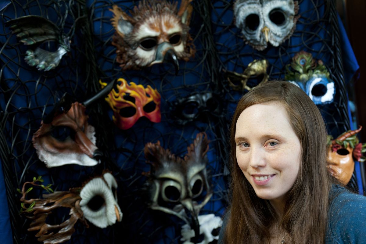 Libertini poses for a photo with some of her leather masks at her home on July 3 in Spokane. They are formed into birds, animals and curious humans. The masks are functional – meant to be worn – as well as decorative, to be hung on the wall. Libertini is also a painter.