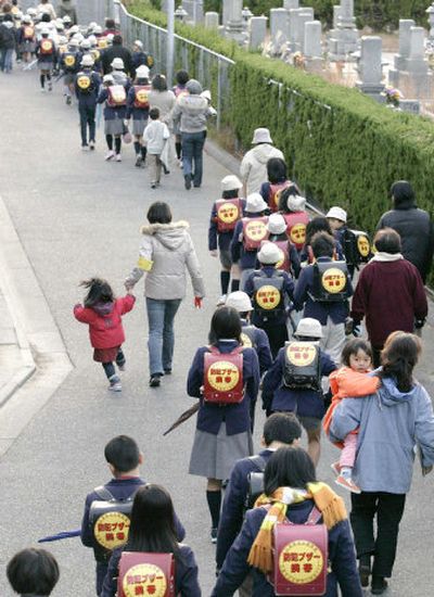 Schoolchildren go to school with parents en masse earlier this week in Hiroshima, where a 7-year-old girl was strangled last month.
(Associated Press / The Spokesman-Review)