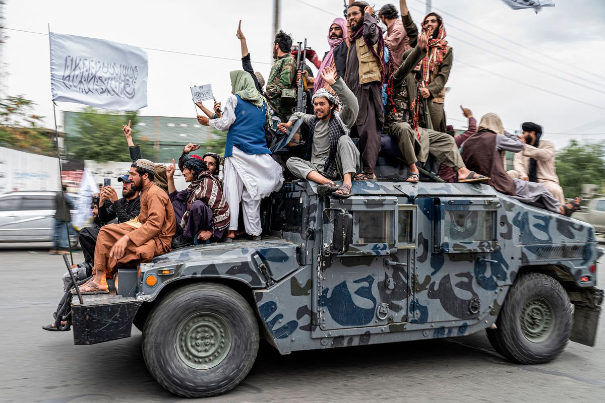 Taliban fighters hold weapons as they ride on a humvee to celebrate their victory day near the U.S. Embassy in Kabul, Afghanistan, on Monday, Aug. 15, 2022. (Wakil Kohsar/AFP/Getty Images/TNS)
