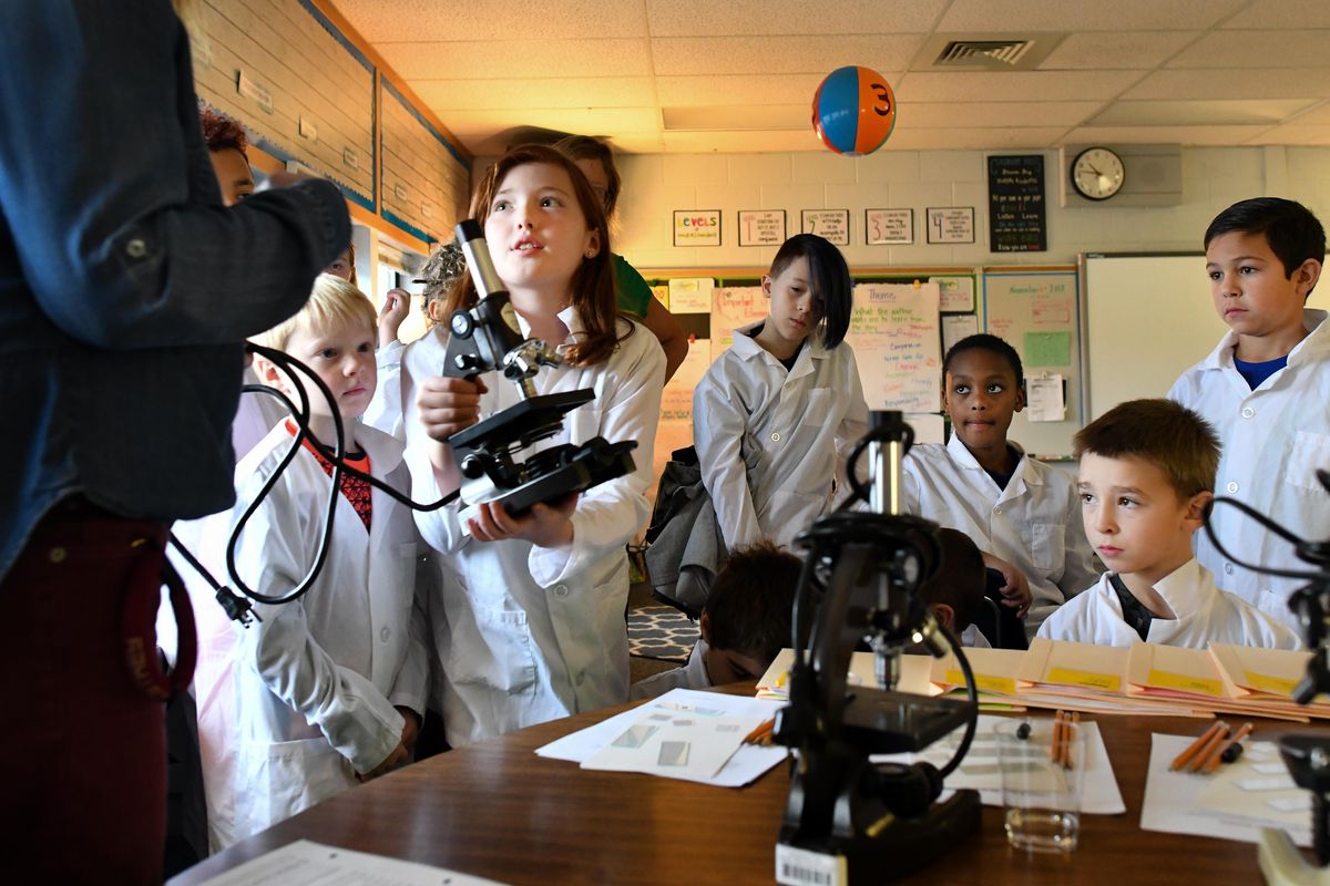 Ada Case demonstrates for her class, and teacher Paige Lewis, left, how to properly hold and carry a microscope during a forensics class held as part of Progress Elementary’s new STEM curriculum on  Nov. 29 at Progress Elementary in Spokane Valley, Wash. (Tyler Tjomsland / The Spokesman-Review)