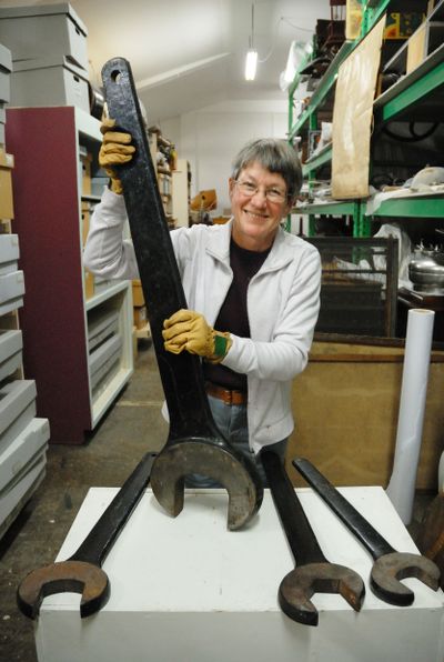 Kathy Monds, Clallam County Historical Society executive director, holds an enormous metal wrench inside the society’s administrative center in Port Angeles, Wash., on Monday. The wrench was used at the Glines Canyon Dam until recently. (Associated Press)