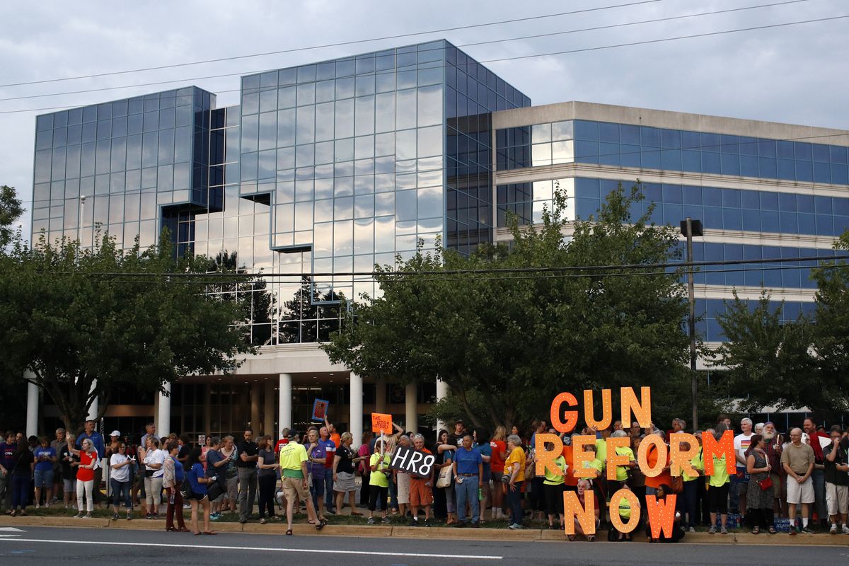 FILE - In this Aug. 5, 2019, file photo, people gather at a vigil for recent victims of gun violence outside the National Rifle Association