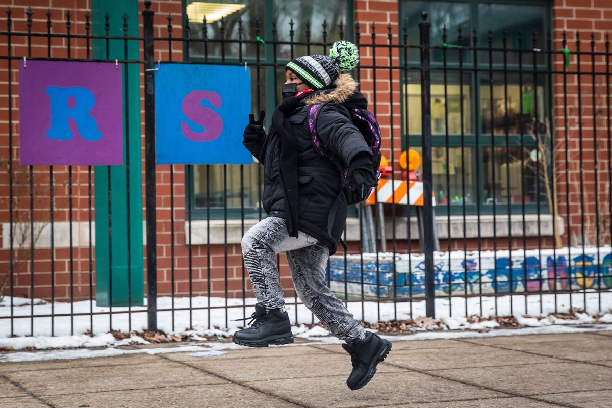 A student skips as they arrive at Jordan Community Public School in Rogers Park on the North Side, Wednesday, Jan. 12, 2022 in Chicago. Students returned to in-person learning Wednesday after a week away while the Chicago Public Schools district and the Chicago Teachers Union negotiated stronger COVID-19 protections.  (Ashlee Rezin)