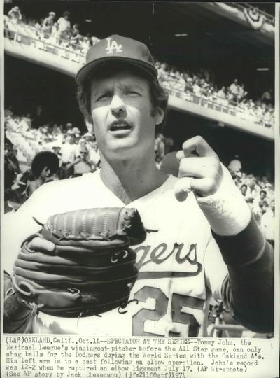 Tommy John, the National League’s winningest-pitcher before the 1974 All-Star Ggame, can only shag balls for the Dodgers during that year’s World Series with the Oakland A’s. His left arm is in a cast following an elbow operation. (Associated Press)