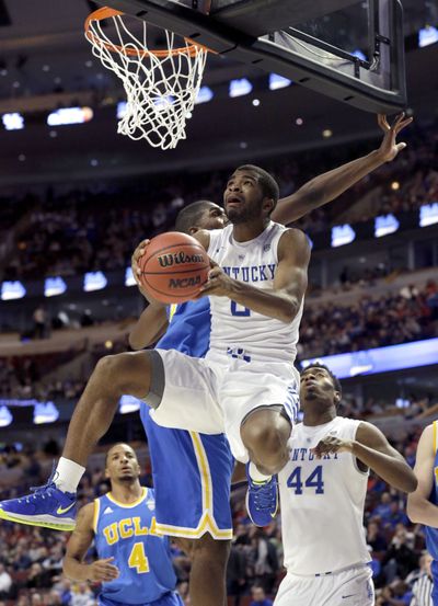 Kentucky’s Aaron Harrison scores over UCLA’s Kevon Looney. (Associated Press)