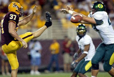 
Oregon's Nick Reed blocks Chris MacDonald's punt during the third quarter. 
 (Associate Press / The Spokesman-Review)