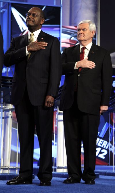 Republican presidential candidates businessman Herman Cain and former House Speaker Newt Gingrich stand for the National Anthem before a Republican presidential debate in Washington on Nov. 22, 2011. (AP Photo/Evan Vucci)