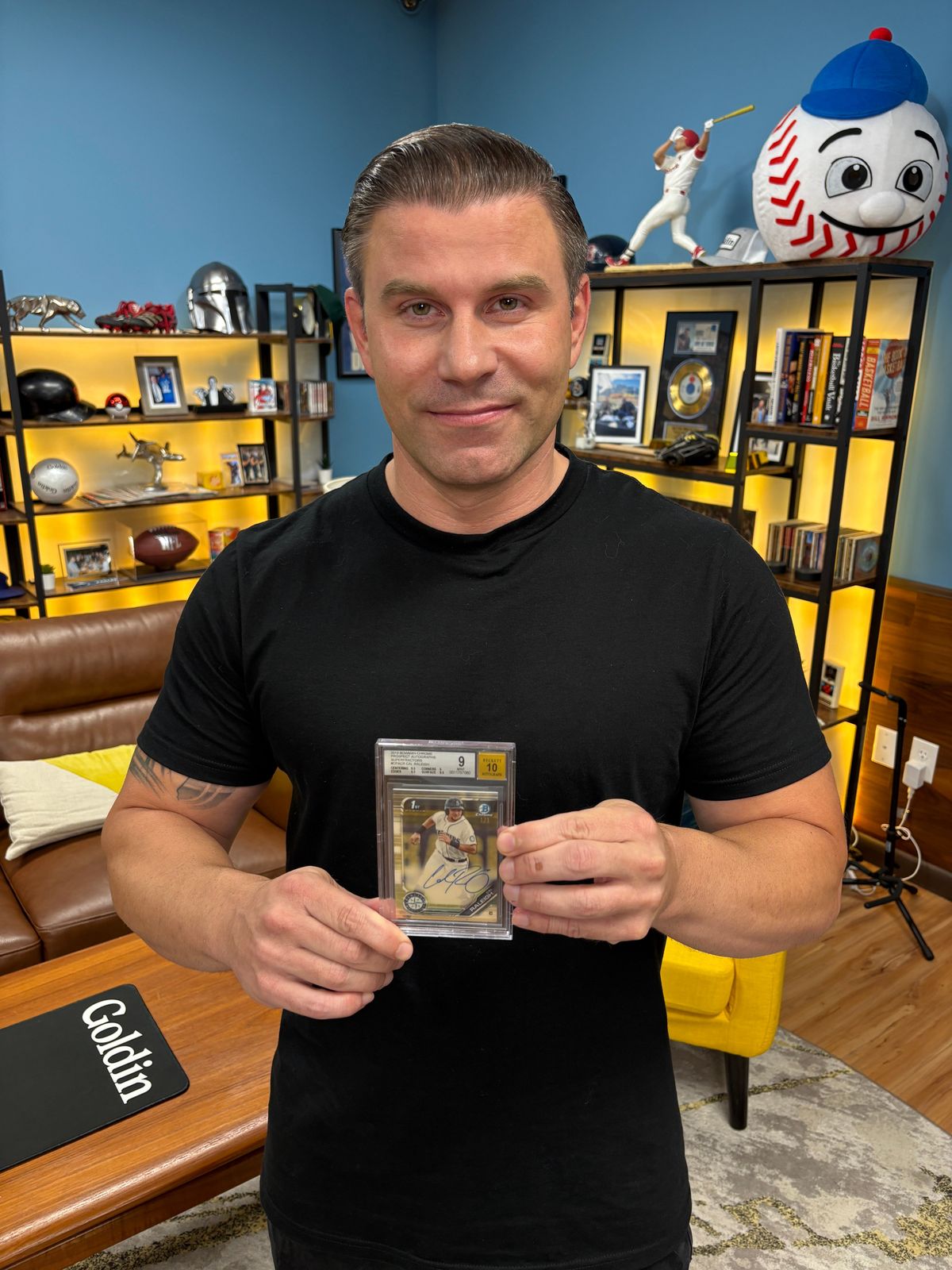 Dave Amerman, head of sales and consignment for Goldin, holds a 2019 Bowman Chrome Prospect Autographs SuperFractor Cal Raleigh-signed rookie card which sold for over $80,000 in a 2025 Goldin auction.  (Courtesy of Goldin)
