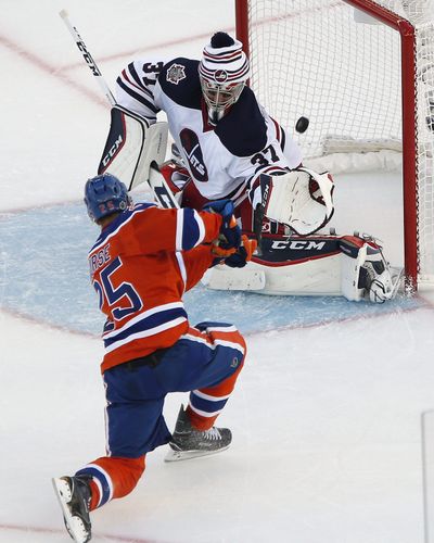 Edmonton’s Darnell Nurse (25) scores on Winnipeg goaltender Connor Hellebuyck in Oilers’ 3-0 outdoor victory. (JOHN WOODS / Associated Press)