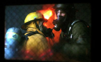
Seen through a training trailer control-room window, Rob Dezellem, right, a volunteer firefighter from Brewster, Wash., waits for trainees  Saturday. 
 (Holly Pickett / The Spokesman-Review)