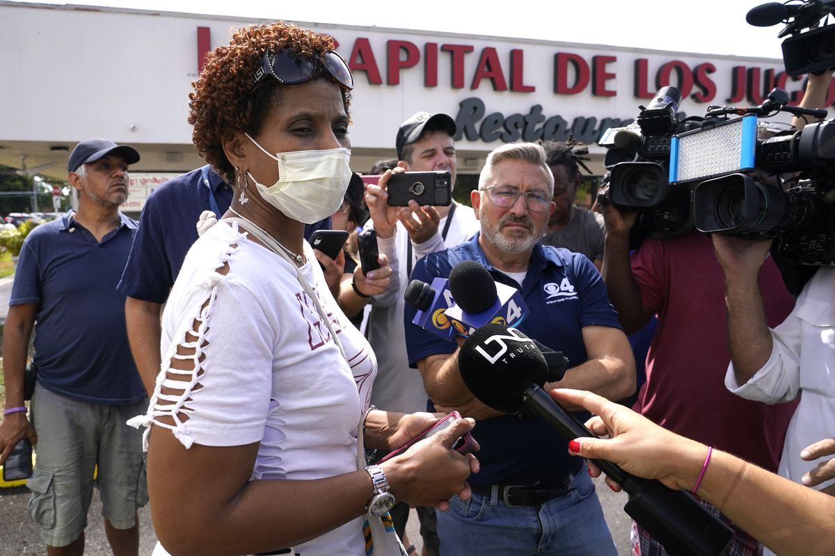 Angelica Green talks with the news media near the scene of a shooting outside a banquet hall near Hialeah, Fla., Sunday, May 30, 2021. Two people died and an estimated 20 to 25 people were injured in a shooting outside a banquet hall in South Florida, police said. The gunfire erupted early Sunday at the El Mula Banquet Hall in northwest Miami-Dade County, near Hialeah, police told news outlets. Green said her son and nephew were injured in the shooting.  (Lynne Sladky)