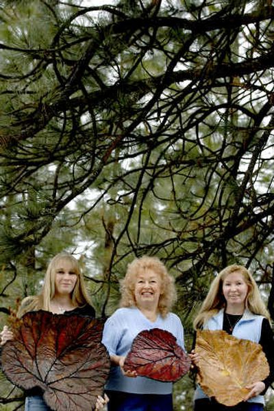 
From left, Jennifer Borley, Ruth Chase and Kathy Moate create cement leaves and yard decorations and sell them at the farmers' market in Hayden. 
 (Kathy Plonka / The Spokesman-Review)