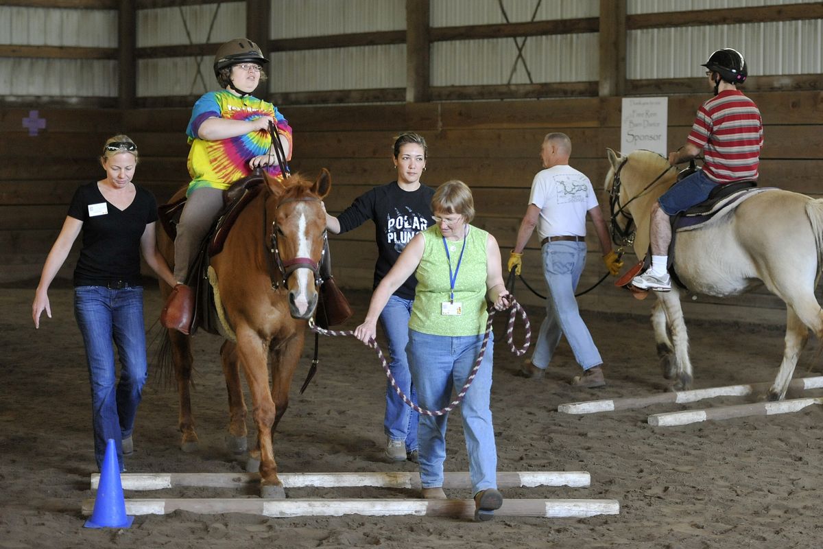 Debra Goodrich, atop Harley, left, and Richard Bubigk, on Loki, participate in a Free Rein riding lesson recently at the Westar Ranch. Volunteers, from left: Amy Bistline, Dahdia Hicks and Bev Wylie, in green, assist Goodrich. Jim Demarest and Nancy Duncalfe work with Bubigk. (Dan Pelle)
