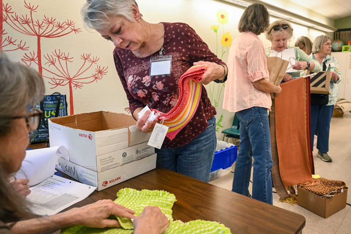Susan Boyson delivers scarves, shawls and dish towels she made during a meeting of the Spokane Handweavers’ Guild on Oct. 8 at the Unitarian Universalist Church. The group is preparing for its upcoming show and sale Friday and Saturday at Barrister Winery.  (DAN PELLE/THE SPOKESMAN-REVIEW)