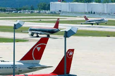 
Northwest Airlines planes sit at gates as one plane lands and another taxis to the runway at Minneapolis-St.Paul International Airport.
 (Associated Press / The Spokesman-Review)