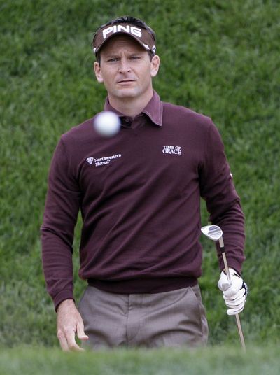 Co-leader Mark Wilson watches his bunker shot on the 18th hole. (Associated Press)