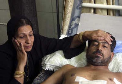 
Associated Press Soad Ali sits with her husband, Hassan Jabar, 37, in a Baghdad hospital Thursday. Jabar was shot four times by Blackwater guards in the Mansour neighborhood.
 (Associated Press / The Spokesman-Review)