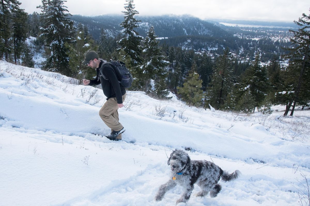Jason Evans, left, hikes with his dog Cosmos on Thursday Jan. 24, 2019. Evans bought about 100 acres of land on Canfield Mountain in Coeur d