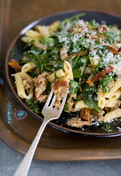 Spicy Sausage and Arugula Penne uses Parmesan cheese, but an aged gouda or crumbled feta would be delicious, too. (Associated Press)