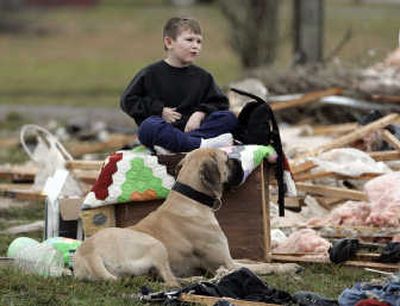 
Michael Keisling, 5, and his dog Mattie sit among the rubble that was their house and watch others begin the cleanup in Hartsville, Tenn., on Wednesday after severe storms went through the area the night before. Associated Press
 (Associated Press / The Spokesman-Review)