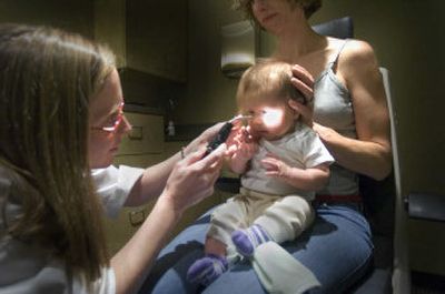 
Four-month-old Jaea Ledgerwood sits with her mother Katrina, while Dr. Heavin Maier works with her testing her sight last week. The exam is part of the InfantSEE program which provides free eye exams to babies.
 (Christopher Anderson/ / The Spokesman-Review)