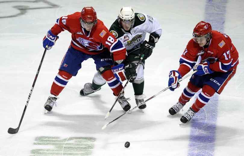 Spokane Chiefs Reid Gow (18) and Mitch Holmberg (17) get to the puck before Everett's Teal Burns Wed., Dec. 14, 2011, in the Spokane Arena. (Colin Mulvany / The Spokesman-Review)