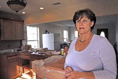 
Janet Meaut in her East Biloxi, Miss., home. Meaut and her husband have been staining cabinet doors and installing them themselves after a contractor stole thousands of dollars from them without completing work on the flood-damaged home. 
 (Associated Press / The Spokesman-Review)