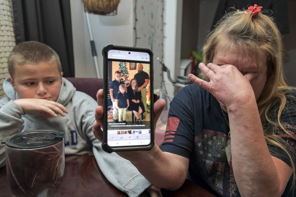 Darra Ann Morales, right, shows a photo of her son Chaz Morales and his family on her phone, as Chaz Jr., 10, comforts his grandmother at their home in Slidell, La., Wednesday, April 14, 2021. Darra Ann Morales is the mother and Chaz Jr. is the son of Chaz Morales, who is one of the crew members missing from the capsized vessel Seacor Power that departed from Port Fourchon when severe weather struck Tuesday.  (Max Becherer)