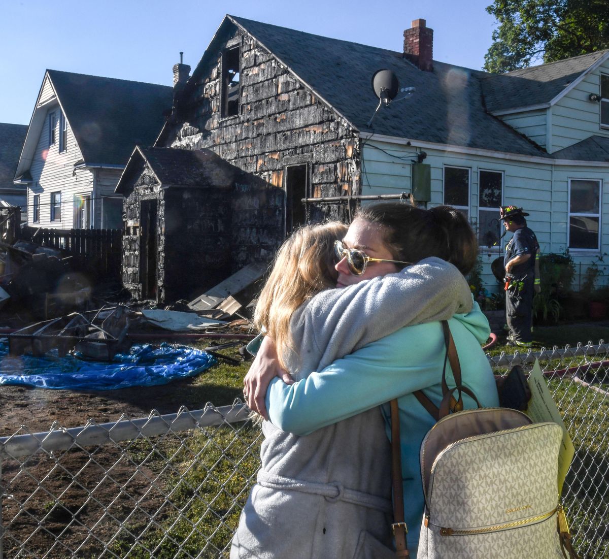 Homeowner Kathy Barton, left, gets an embrace from her daughter, Miranda Dowdy, on Friday, June 28, 2019, after a fire destroyed the rear of Barton’s house and several garages. Four people and four dogs made it out of the burning home at Queen Avenue and Stone Street in Spokane’s Hillyard neighborhood. (Dan Pelle / The Spokesman-Review)