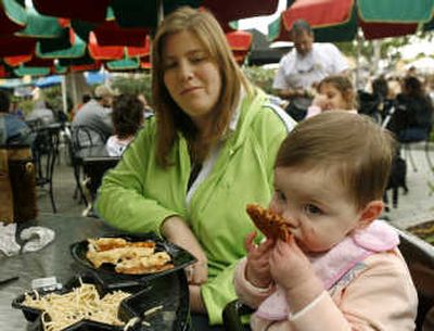 
Sheri Medwed watches as her 15-month-old daughter, Allie, eats pizza at Universal Studios Hollywood. Pizza chains are facing a 55 percent increase in the wholesale price of cheese.Associated Press
 (Associated Press / The Spokesman-Review)